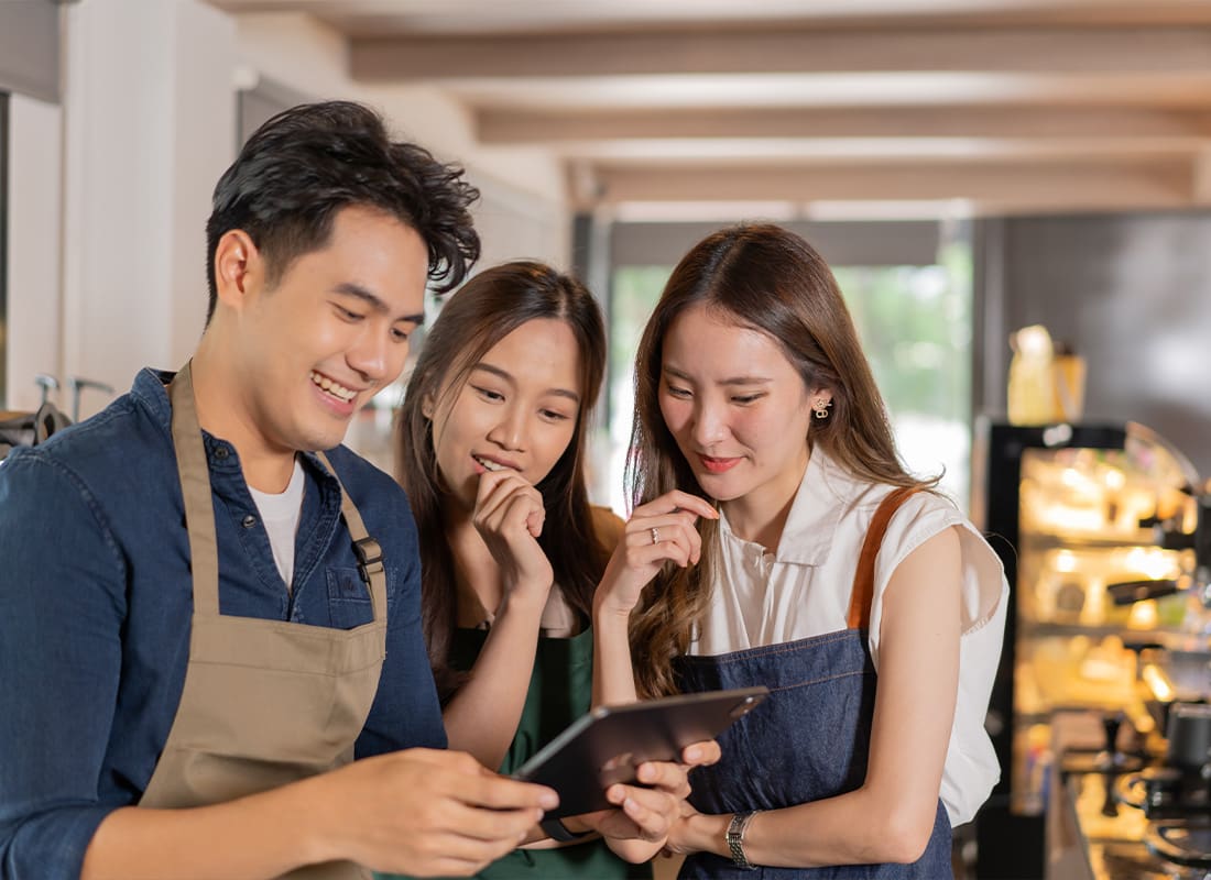 Business Insurance - Cafe Employees Having a Discussion About Work and Menus by Using a Tablet