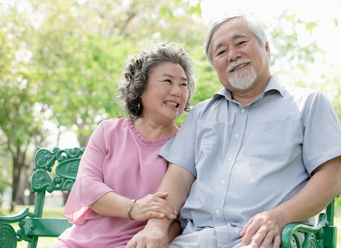 Medicare - Healthy Senior Couple Relaxing While Seated in the Park Together